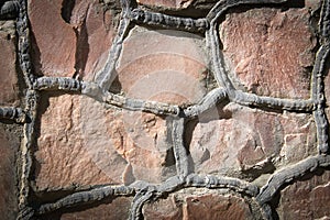 Closeup of masonry stone wall with irregular pattern, seamless texture or background. Vignetted