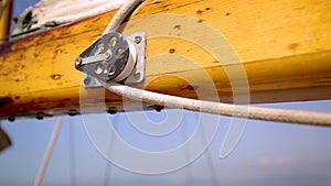 Closeup of the mast of a wooden antique Sail boat navigating in the ocean sunny day showing the wooden parts and