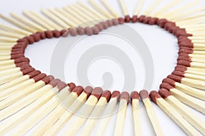 Closeup of match sticks arranged to form a heart shape