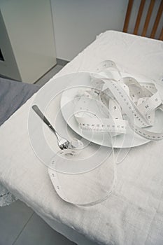 Closeup of the measure tape on the plate - the concept of dieting