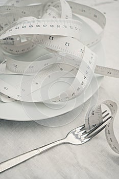 Closeup of the measure tape on the plate - the concept of dieting