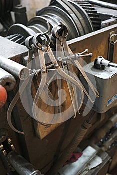 Closeup of a measuring special equipment like calipers, dividers & compass of old Lathe Machinery. Vintage Industrial Machinery in