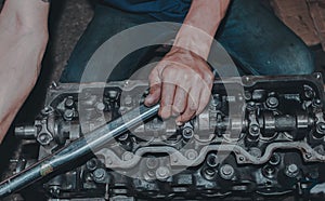 Closeup of a mechanic fixing an internal combustion engine