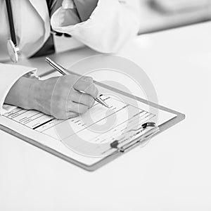 Closeup on medical doctor woman writing in clipboard