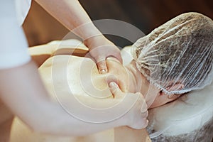 Closeup on medical massage therapist massaging clients neck
