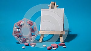 Closeup of medical pill box with doses of tablets for daily take medicine with white pink drugs and capsules with paper