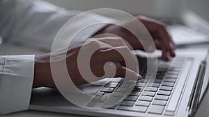 Closeup of medical professional typing on laptop keyboard during working day in clinic office spbas.