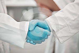 Closeup, medical and research with handshake, people and agreement with promotion, cooperation and partnership. Teamwork