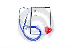 Closeup of medical stethoscope on a rx prescription, red heart isolated on white background