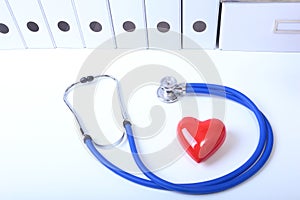 Closeup of medical stethoscope on a rx prescription, red heart on white background