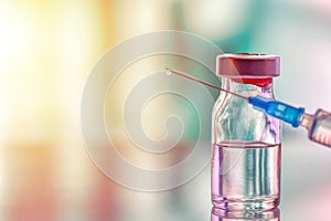 Closeup of medicine vial or flu, measles vaccine bottle with syringe and needle for immunization on vintage medical background,