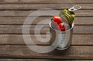 Closeup of metal can full of red delicious tomatoes on the wooden table.Empty space