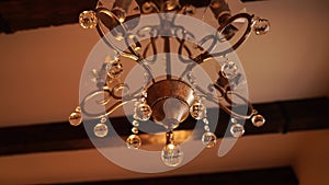 Closeup of a metal chandelier hanging from the ceiling in a room