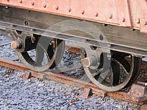 Closeup of metal train wheels on the track during daylight