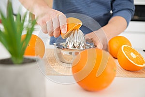 Closeup metallic juice squeezer and oranges