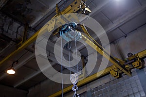 Closeup of metallic lathe crane against factory industrial interior background