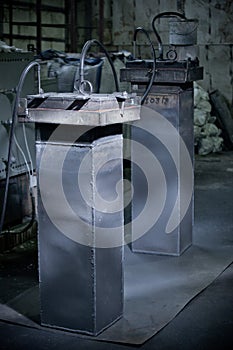 Closeup of metallic lathe working against factory industrial interior background