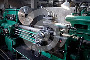 Closeup of metallic lathe working against factory industrial interior background