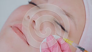 closeup of micro-injections of pharmaceutical preparations in face skin of woman in beauty clinic