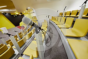 Closeup microphone against auditorium with chairs photo