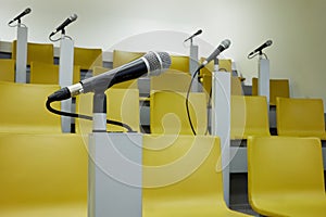Closeup microphone in holder in auditorim with photo