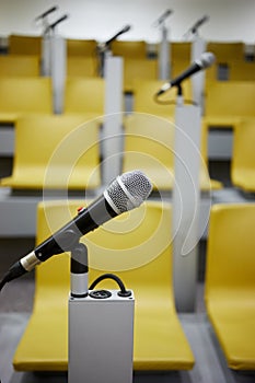 Closeup microphone in holder in auditorim with photo