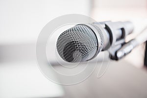 Closeup of microphone in lecture room background speech in seminar convention hall room. Mic speaker of teacher on podium in