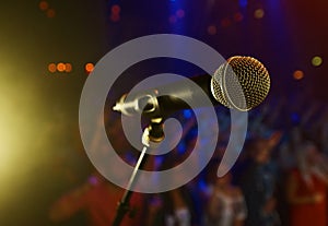 Closeup, microphone and stage performance in theater with audience and sound equipment for concert or singing. Audio