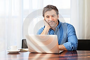 Closeup of a middle-aged man, bored on a curtains background at the office