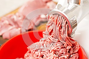 Closeup of minced meat coming out from grinder.