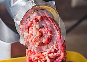 Closeup of minced meat coming out from grinder. Healthy homemade minced meat