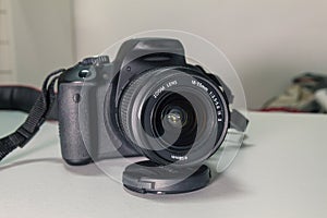 Closeup of modern black DSLR camera on white table