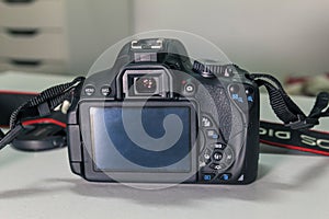 Closeup of modern black DSLR camera on white table