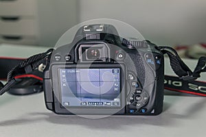 Closeup of modern black DSLR camera on white table