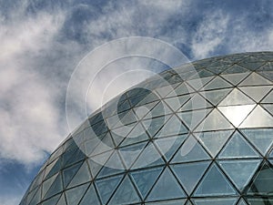 closeup of modern building under blue sky and white clouds