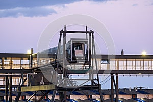 closeup of a modern cruise ship terminal with a glass passenger boarding bridge against a vivid sky during the sunset