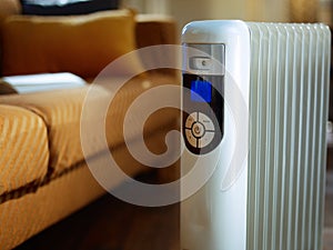 Closeup on modern floor oil radiator with thermostat