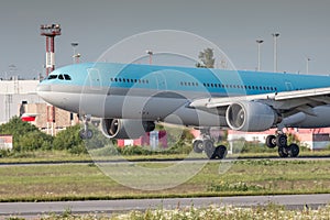 Closeup of modern passenger airplane landing with touchdown on the runway at the airport in summer