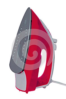 Closeup of a modern red electric steam iron for ironing household laundry. Macro photograph