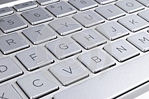 Closeup of a modern silver laptop computer keyboard. Laptop keyboard. Detail of the new and ergonomic computer keyboard