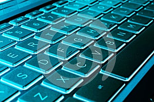 Closeup of a modern silver laptop computer keyboard. Laptop keyboard. Detail of the new and ergonomic computer keyboard. Blue tone