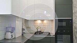 Closeup of modern white and grey kitchen interior, tilt camera movement