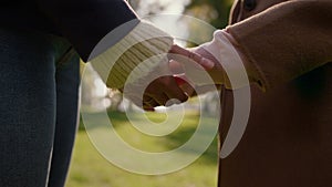 Closeup mom hands joining daughter in autumn park. Loving parent caress support