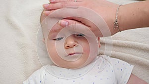 Closeup of mother applying cream for moisturizing and cleaning her baby's face. Concept of newborn baby hygiene, health