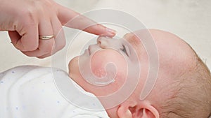 Closeup of mother applying medical ointment on baby's skin suffering from acne and dermatitis