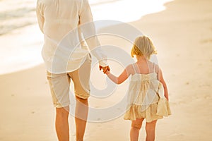 Closeup on mother and baby girl walking on beach