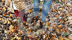 Closeup mother with baby walking by autumn leaves outdoor