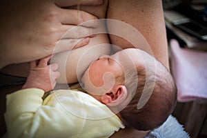 Closeup of a mother breastfeeding her newborn baby at home after the hospital