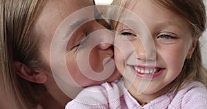 Closeup mother and daughter make funny faces, staring at camera