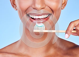 Closeup, mouth or woman brushing teeth in studio for dental care, fresh breath or healthy smile on blue background. Face